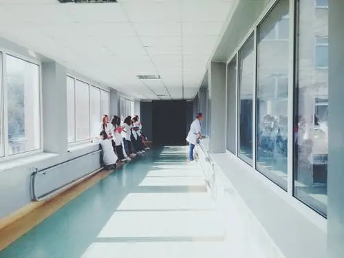 people standing outside hospital room